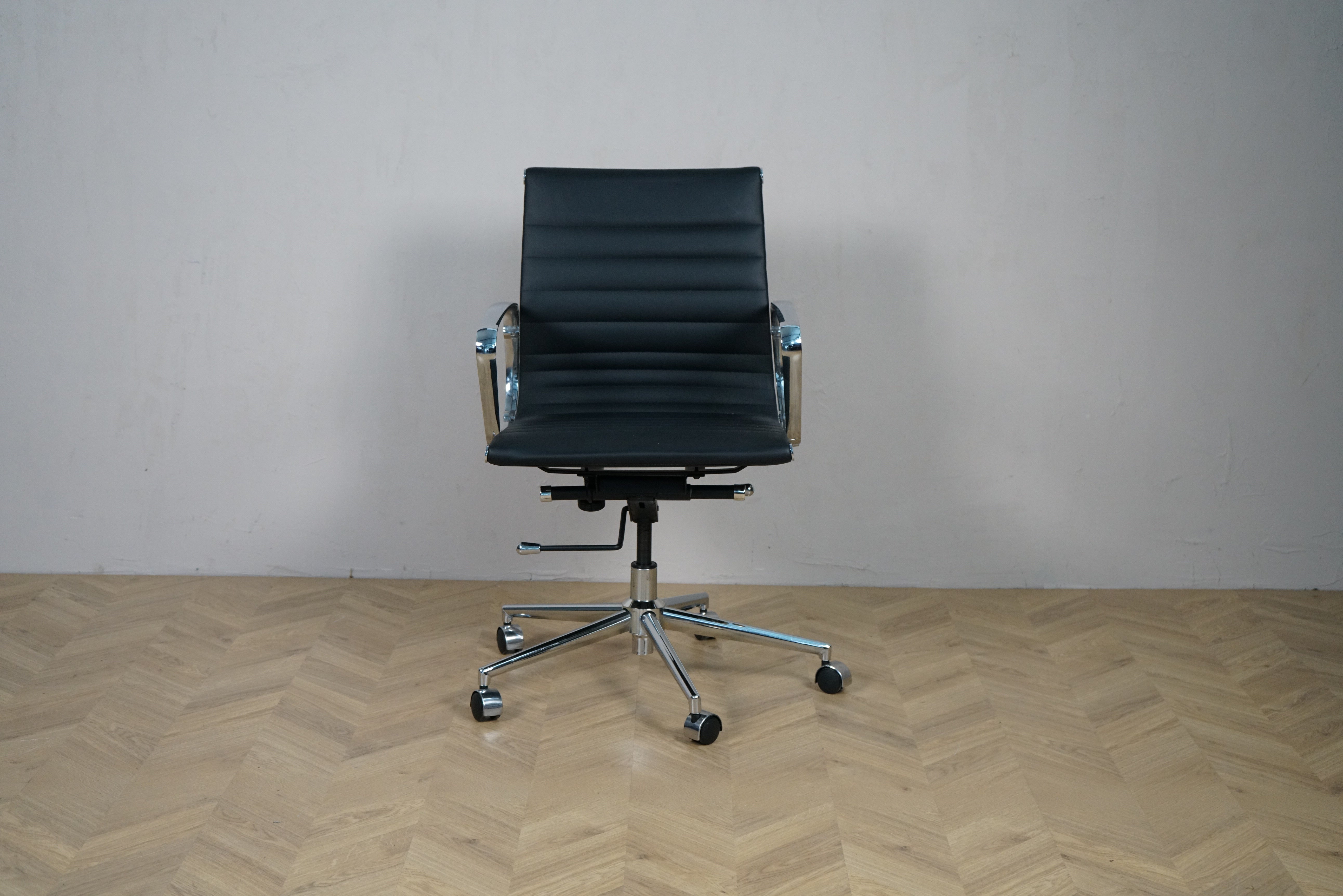 Wye kontorstol i sort læder med lav ryg, krom stel og armlæn – frontvisning